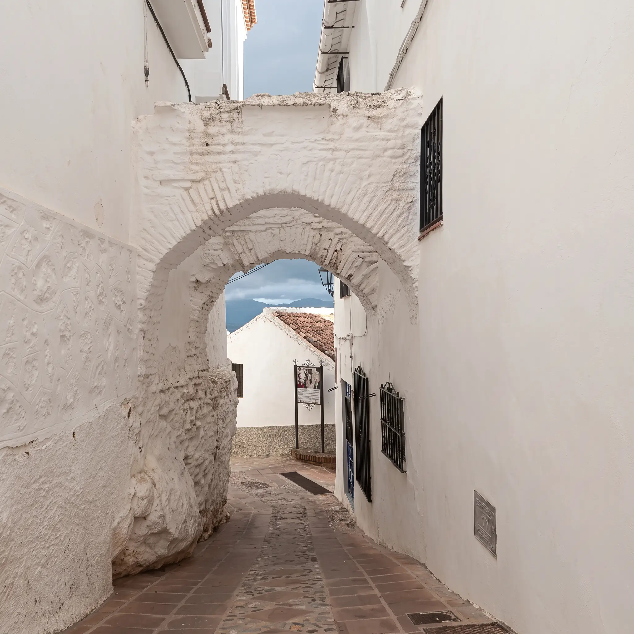 Calle de Comares bajo un arco de piedra